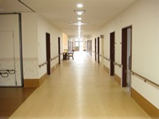施設内のオールバリアフリーの廊下。両側に個室のドアがある様子が分かる
