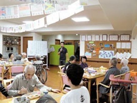 利用者とスタッフが会話している様子。施設内のリビングスペースの写真