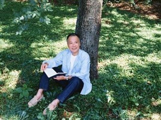 木陰でやすんでいる高齢者男性。涼し気な場所でほほ笑んでいる様子