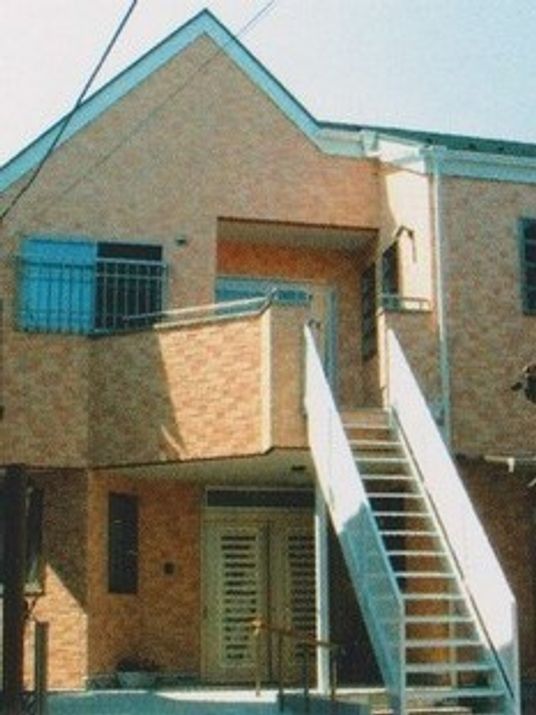 レンガ調の外壁をあつらったホーム外観。２階建てで２階からは屋外でも階段で上り下りできるようになっている。