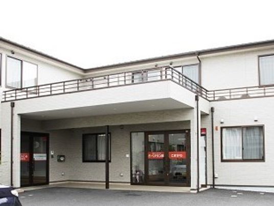 鉄骨造２階建ての建物が写っている写真。ホワイト基調の建物が写っている