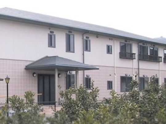 2階建ての建物はツートーンで落ち着いた雰囲気。周辺にはたくさんの木も植えられている。