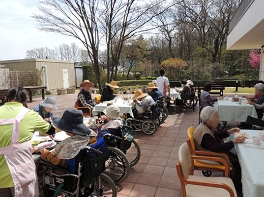 テラス席に並んで居座って食事を楽しんでいる様子。レクリエーションの一場面