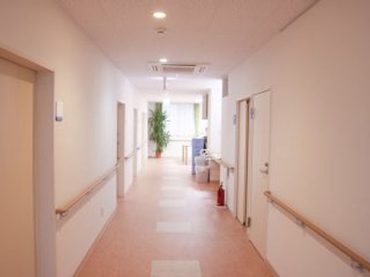 手すりがついた施設内の廊下の様子。奥のほうに広場がある様子