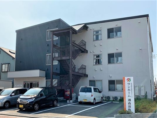 マンション風の建物と駐車場スペースが写っている写真。高齢者向け住宅の外観