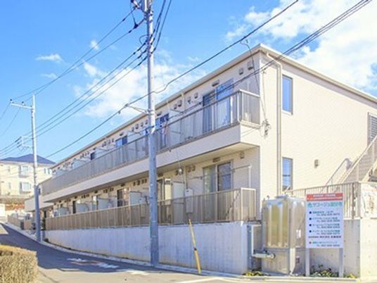 ２階建ての建物が写っている。白を基調にした清潔感のある建物
