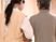 エプロンを付けた女性スタッフに付き添われて歩いている白髪の高齢女性。