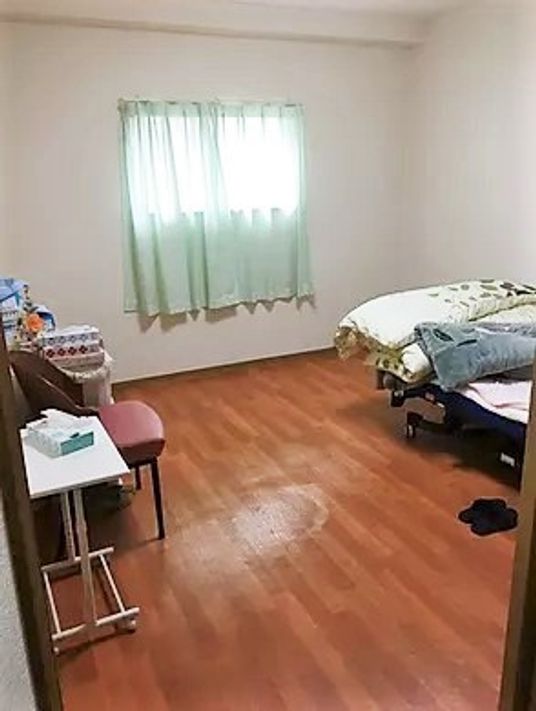 広めの部屋にベッドや生活用品が並べられている様子。施設内の居室の一室