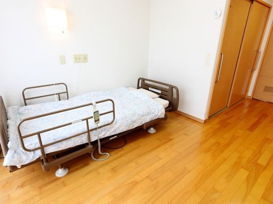 介護用ベッドが置いてある施設内の居室の様子。左側に収納がついている