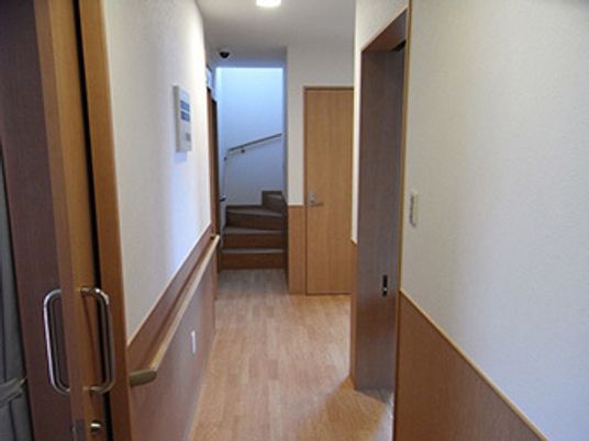 手すりが全域についた館内は木の温かみの感じられる住まい。ドアはすべて引き戸となっている。