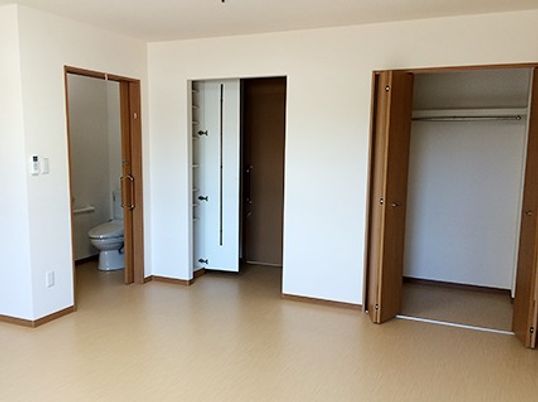 大きな収納と引き戸のドア、トイレなどが付いている二人用の部屋の様子
