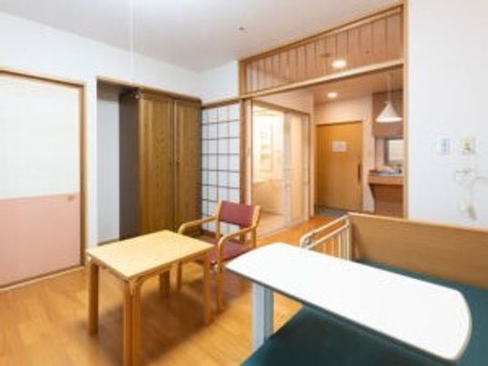 施設内に用意されている個室の様子。介護用ベッドと椅子、机、洗面台などがある様子