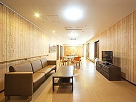 大きなソファやテレビが置かれたリビング。奥にはダイニングテーブルが設置されている。