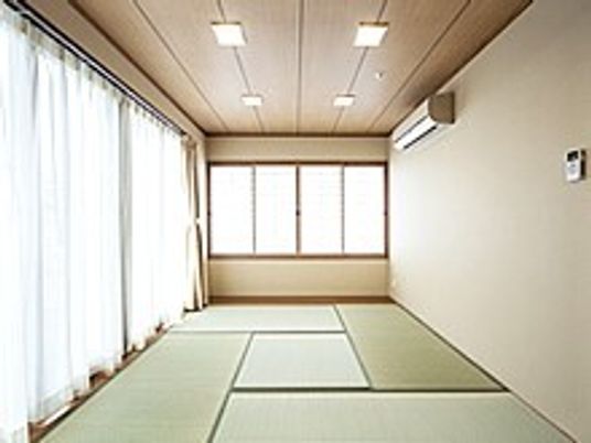 畳敷きのお部屋には大きな窓が付き、壁にはエアコンも設置されている。