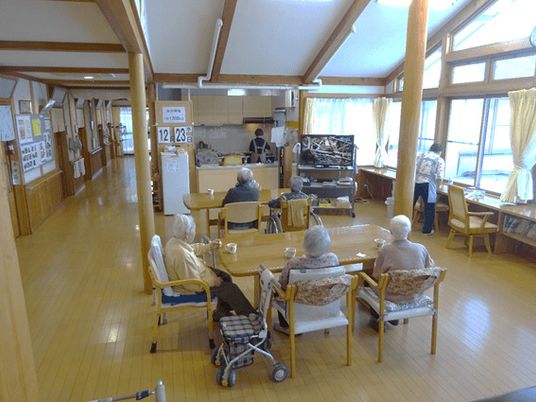 梁が見えるデザインのグループホームの様子。住まい部分でくつろぐ高齢者の様子