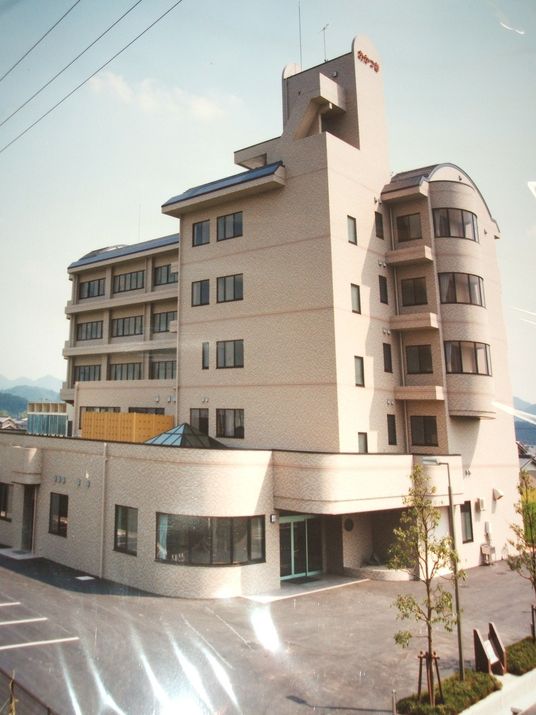 6階建てのベージュの建物は高さもあり、広い駐車場が付いている。