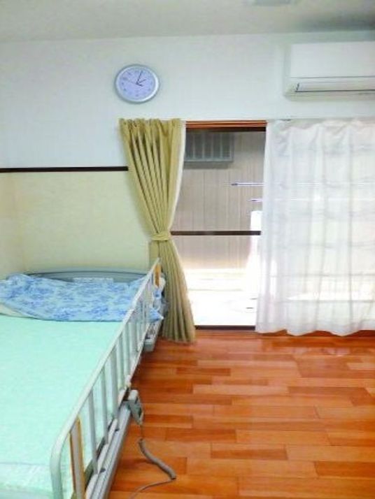フローリングの部屋にはエアコンが付き、時計が設置されている。寝具付きのベッドもある。