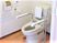 便器の両側に可動式の手啜り、壁に普通の手すりがついている施設内のトイレの様子