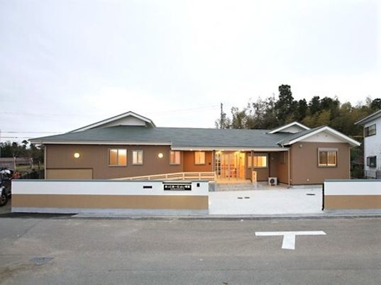 一軒家のような風合いの建物の外観写真。広めの敷地内にある施設の外観