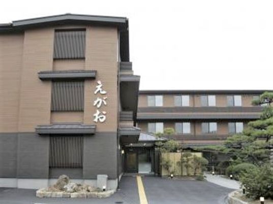 シックな色合いの外観が印象的な建物。えがおの看板が見える建物の外観