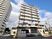 白いマンションは周辺にも高い建物がある。街中の風景。