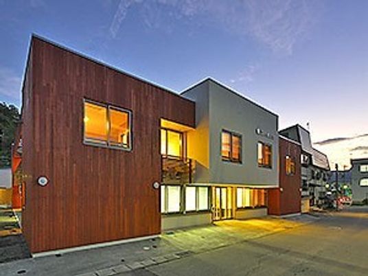 ２階建ての建物。白とブラウンの落ち着いた雰囲気。