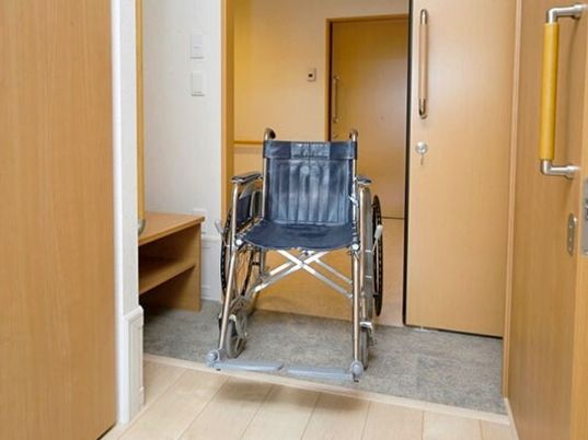 車いすが置かれた居室のエントランス。スライド式のドアが設置され、段差は解消されている。