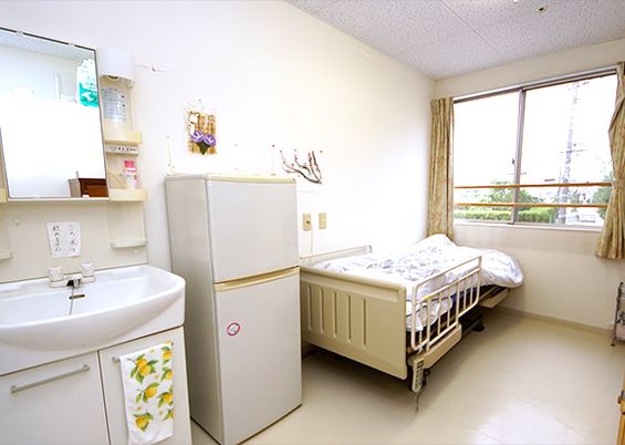 介護用ベッドと冷蔵庫、洗面台などが設置されている個室