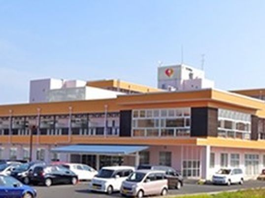 2階建ての建物には広い駐車場が付き、玄関先には青い屋根もついている。