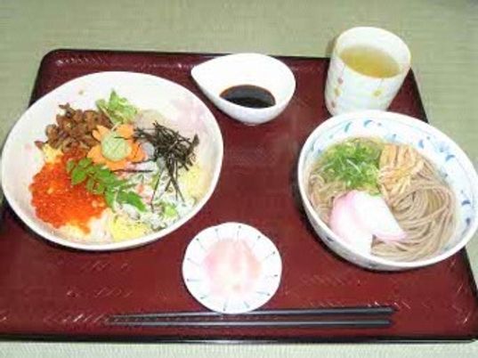 イクラが乗ったちらし寿司や掛けそばなどが並んだトレーにはしょうゆやお茶、箸なども置かれている。