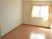 フローリングの部屋には大きな窓が付いていて、カーテンが設置されている。家具や家電は置かれていない。