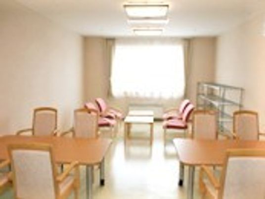 2組のテーブルセットと応接セットが並んだ部屋。