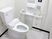 ふたなしの便座が設置され、手洗い場や呼び出しボタンはトイレットペーパーホルダーのそばにある。