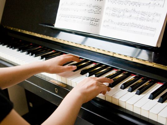 ピアノを弾いている人の手を写したもの。施設で行われている音楽療法