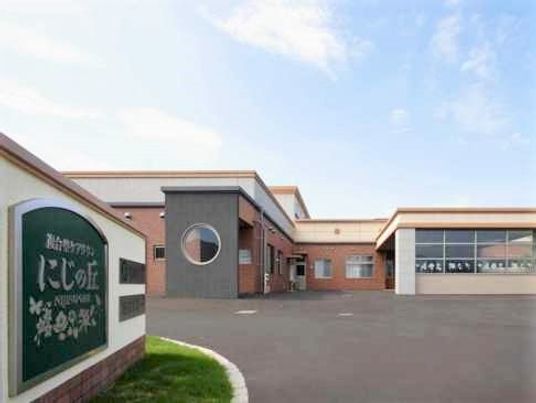 広い敷地内に２棟が連なるようにして建っている。モダンなデザインと色合いが印象的な高齢者向け施設の外観