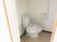 L字型の手すりが付いた高齢者用トイレの様子。ウォシュレットの設備もついている