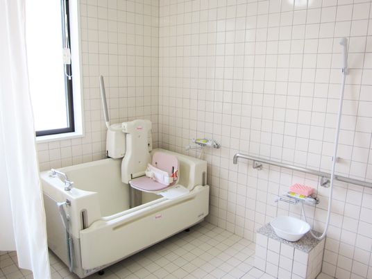 座ったままご入浴いただける介護仕様の浴槽の様子。シャワーや手すりなどが取りつけてある