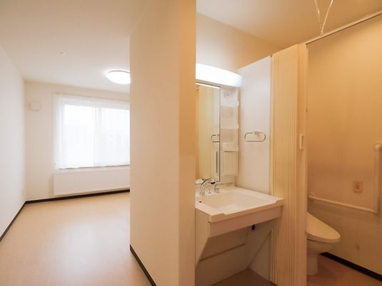 カーテンで開け閉めするタイプのトイレや車いす対応の洗面所が付いた段差のない部屋。