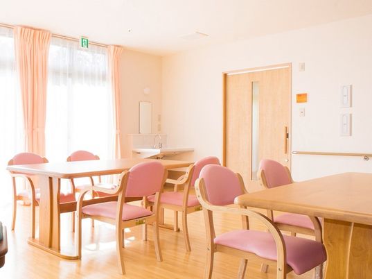 木製の4人掛けのテーブルが並ぶ食堂。大きな窓が付き、屋外の景色を眺めることができる。