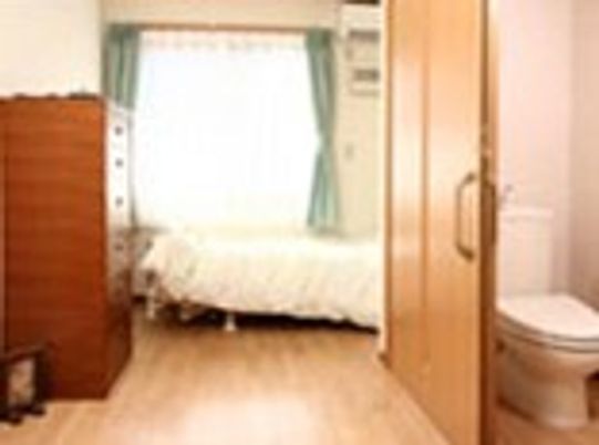 収納家具やベッド、トイレがついた広々とした居室。