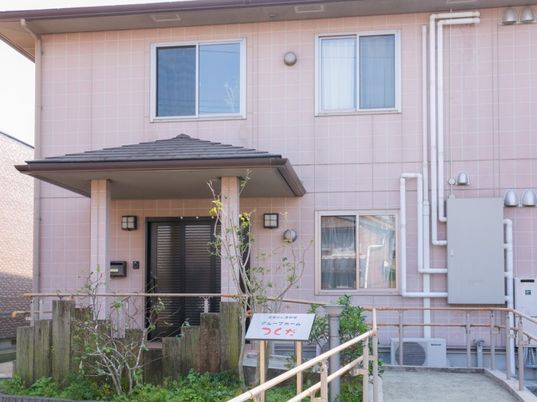 ２階建ての建物は一般の住宅のような雰囲気。なだらかなスロープが設置されている。