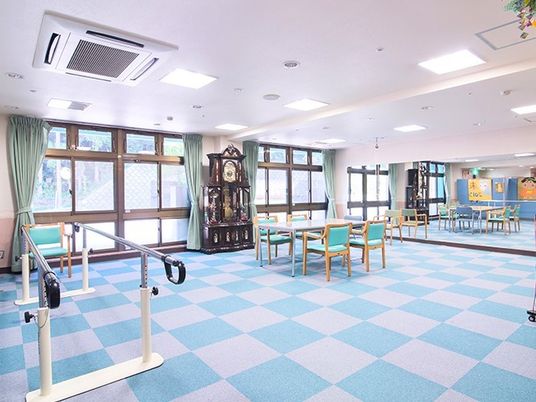 講師柄のじゅうたんが敷いてある広めのトレーニングルーム。向こう側に一面の鏡