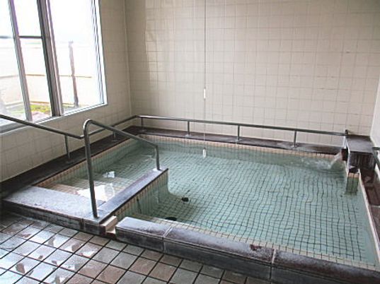 大きな浴槽が設置された浴室には大きな窓があり、タイル張りの清潔感があふれる空間となっている。