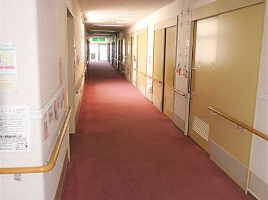 赤いカーペットが敷かれたまっすぐな廊下は両サイドに手すりと居室のドアが設置されている。