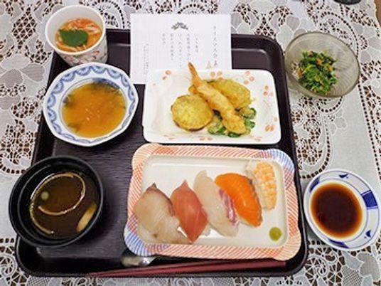 赤だしと握りずし、てんぷらが乗っている豪華な行事食の写真