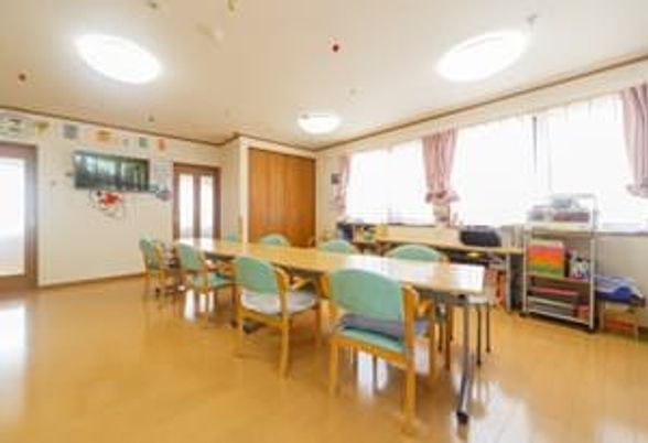 大きな窓がたくさんついている共有スペースには木製のテーブルセットが置かれ、テレビもある。