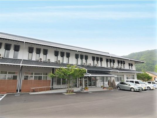横に長い２階建ての建物。白壁にグレーの瓦屋根が和風の雰囲気。