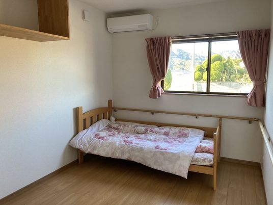 お部屋にはベッド、エアコン、窓が設置されている。
