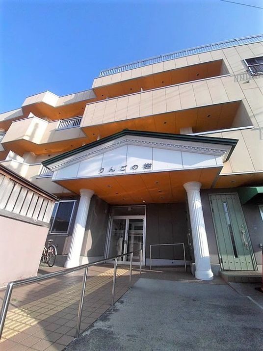 玄関の屋根部分には施設名が書かれ、3階建ての建物の各フロアにベランダが付き、屋上もある。