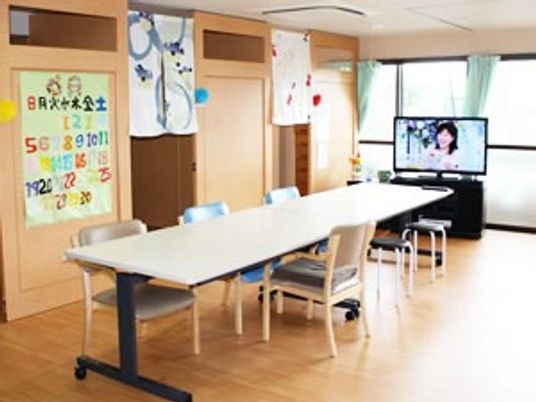 ダイニングテーブルの向こうにはテレビがセットされ、大きな窓があり、明るく家庭的な雰囲気。